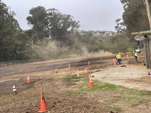 Image of workers compacting the ground in the dog meadow in preparation for receiving sod