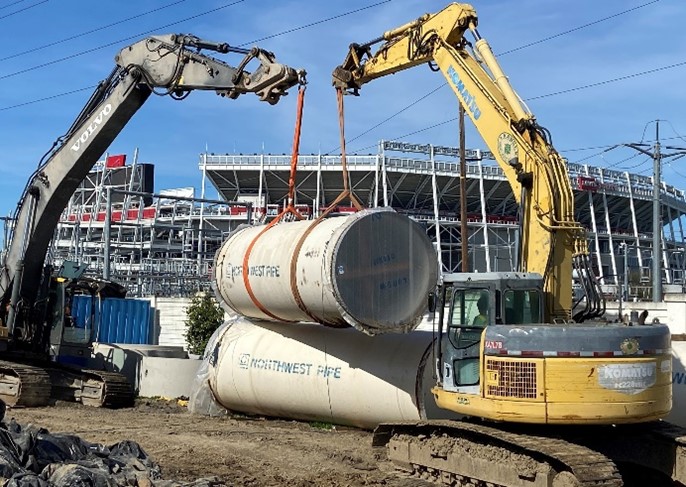 Photo of two cranes supporting a pipeline