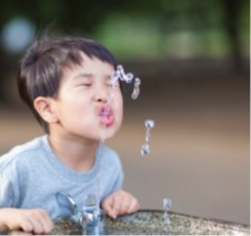 child at water fountain