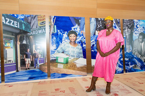 Local San Francisco artist Kenyatta A.C. Hinkle in front of her artwork to "Navigating the Historical Present: Bayview-Hunters Point," currently displayed at the Southeast Community Center.