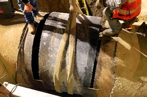 Crews install a 40-inch-long cut pipe section to fix the break in the pipeline. This was later covered in steel mesh and coated with cement mortar.