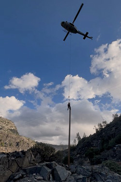 HHWP Line crew “long-lining” from a helicopter to remove a portion of overhead distribution line near O’Shaughnessy Dam in Yosemite National Park