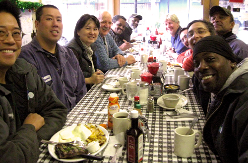 people having a meal at a long, dining table