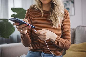 Woman charging her phone prior to a storm