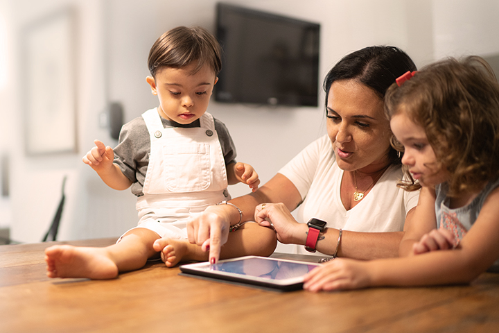 Mother with her two children at the dining table.