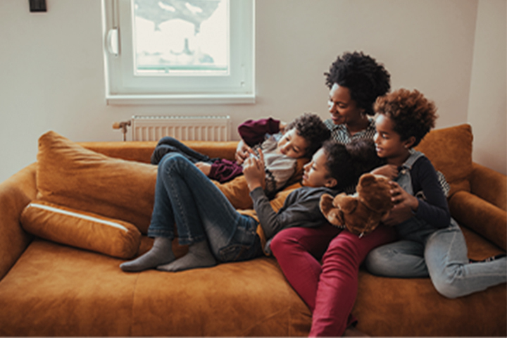 family of four all laying on a couch together