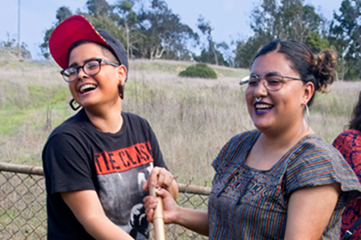 two women wearing glasses smiling and gardening together