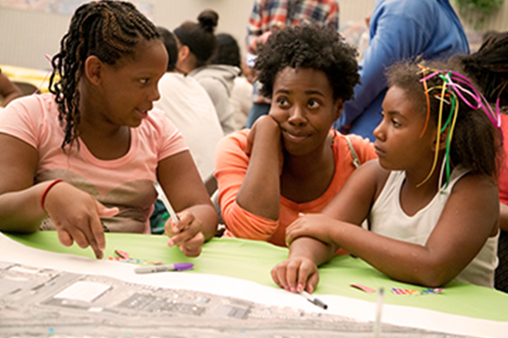 3 young women working together on a map