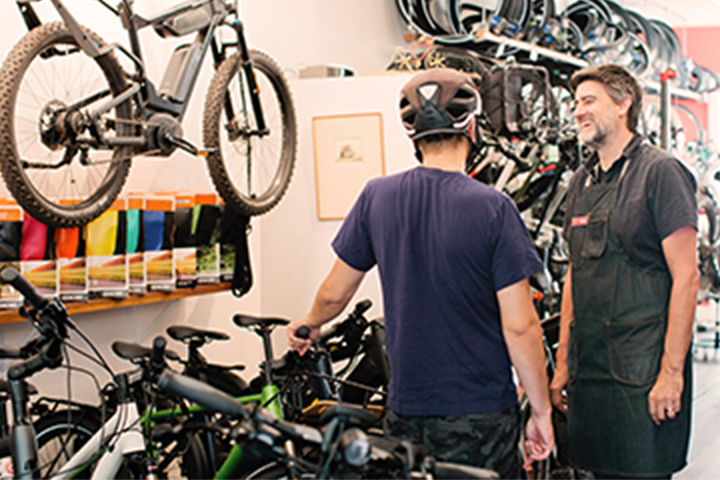 Sales clerk and customer inside a bike shop.