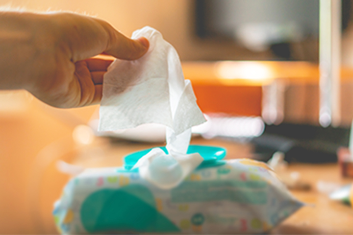 hand pulling out a disposable cloth from its packaging
