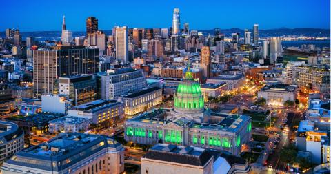 San Francisco skyline with City Hall lights in green.