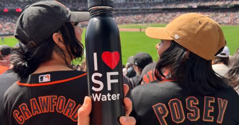 I heart SF Water bottle at a Giants game. People wearing a black Crawford and Posey jersey.