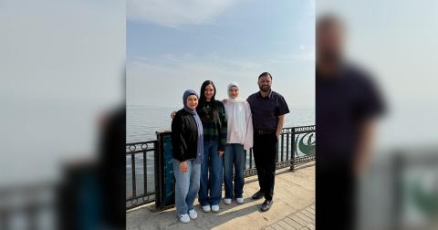 Azim posing for a family picture in San Francisco with his wife and two daughters. 