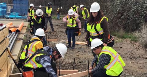 Students are laying out building foundation lines, ensuring squareness when turning 90-degree corners.