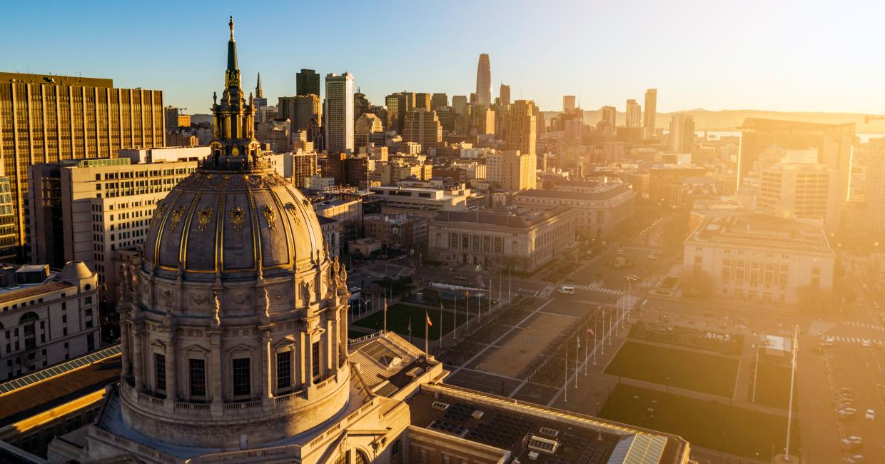 Aerial view of San Francisco City Hall with solar panels and City in background.