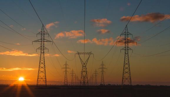 Rows of power lines with the sunset in the background.