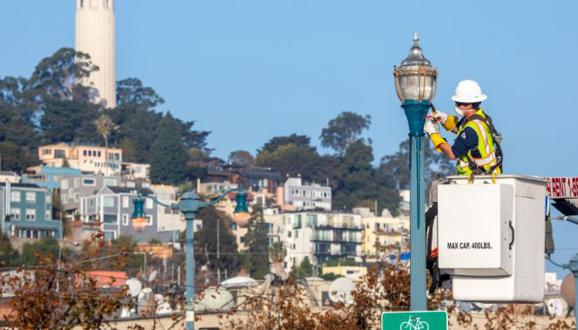 Person in a bucket truck fixing a streetlight.