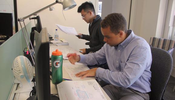Karl Clayter (front) reviewing engineering design plans with fellow intern Kenneth Mai.