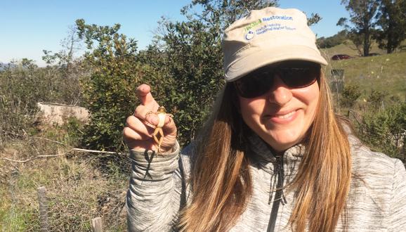 Mia Ingolia poses with a Pacific tree frog.