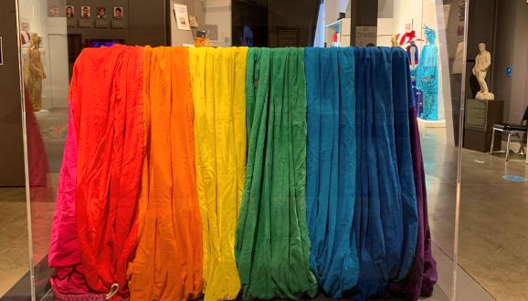 The segment of one of the original rainbow flags created for San Francisco Gay Freedom Day 1978 rests in its case at the GLBT Historical Society Museum; photograph by Andrew Shaffer.