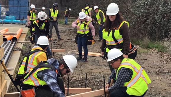 Students are laying out building foundation lines, ensuring squareness when turning 90-degree corners.